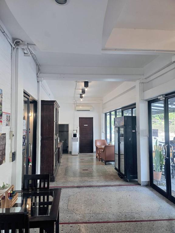 A long, bright lobby corridor with glass frontage, a small seating area and reception furnishings.