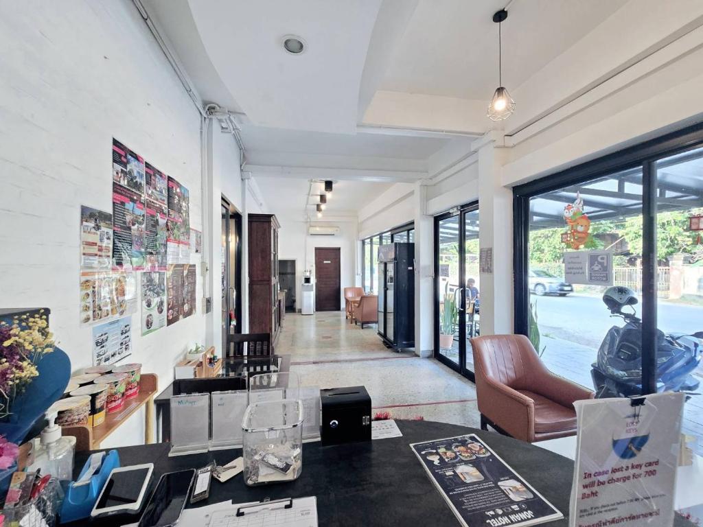 A reception and lounge corridor with seating, street-facing windows and a working table.