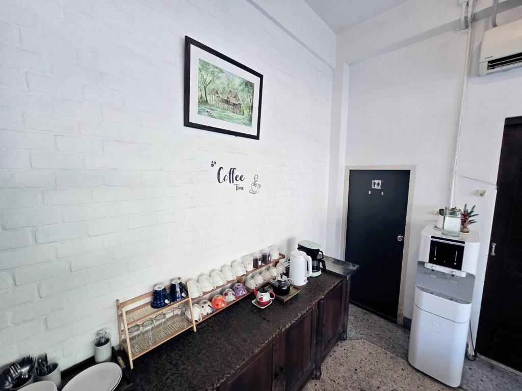 A self-service coffee and tea station arranged on a dark wooden counter in the lobby.