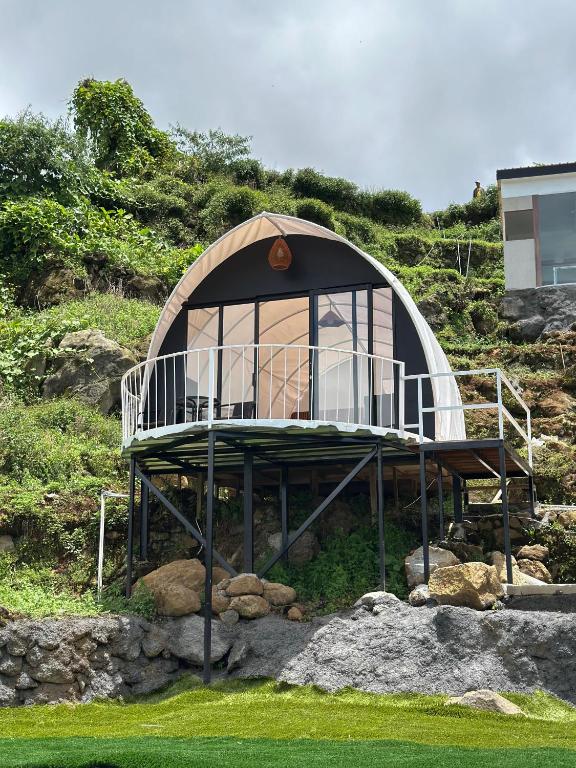 a small dome house with a balcony on a hill at Glamping Dieng Sunrise Point Larva Camp in Kejajar