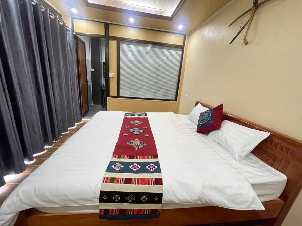 a bedroom with a bed with a red blanket on it at MAI CHAU inn in Mai Châu