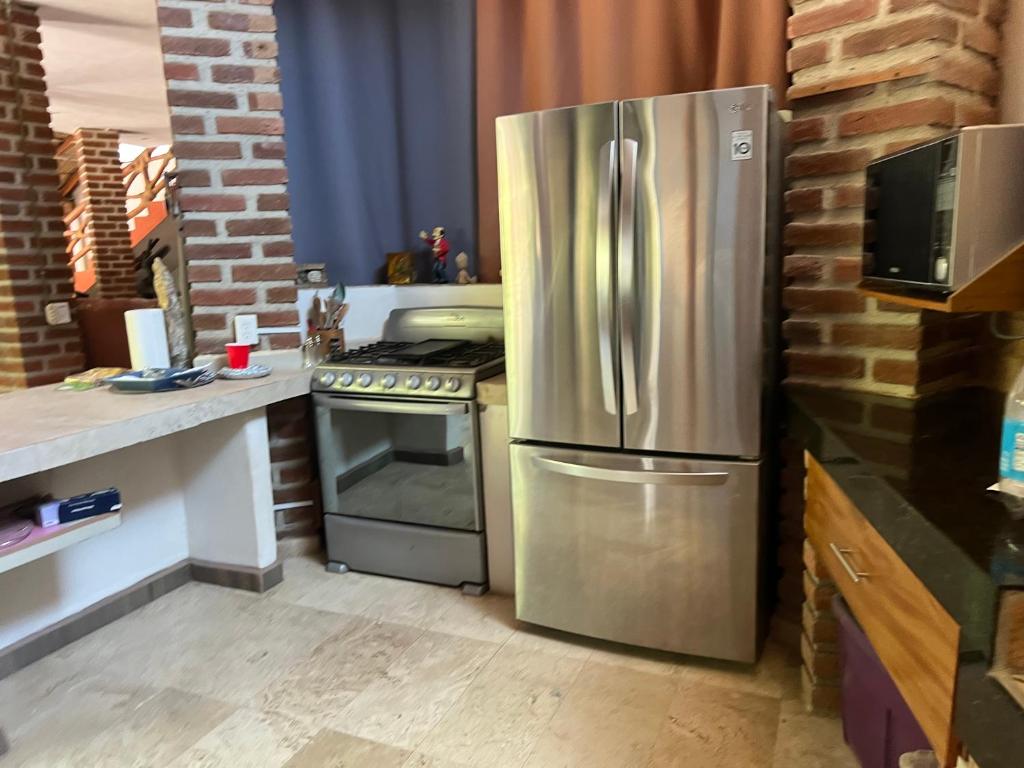 a kitchen with a stainless steel refrigerator and a stove at Condominio La Palapa in Bucerías