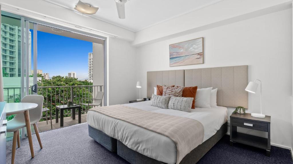 a bedroom with a large bed and a balcony at Mantra Hotel Room in Cairns