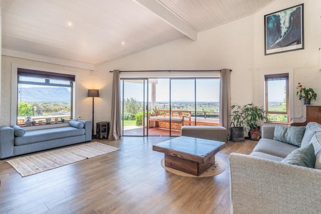 a living room with a couch and a table at 3BR Lakeside Home Mountains Beach Nearby in Cape Town