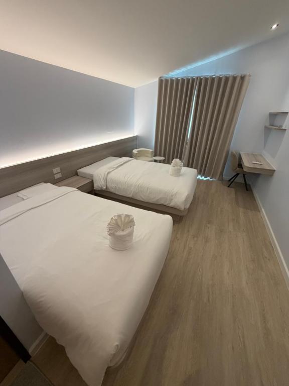 a hotel room with two beds and a window at ของขวัญรีสอร์ท in Ban Khlong Ai Kok