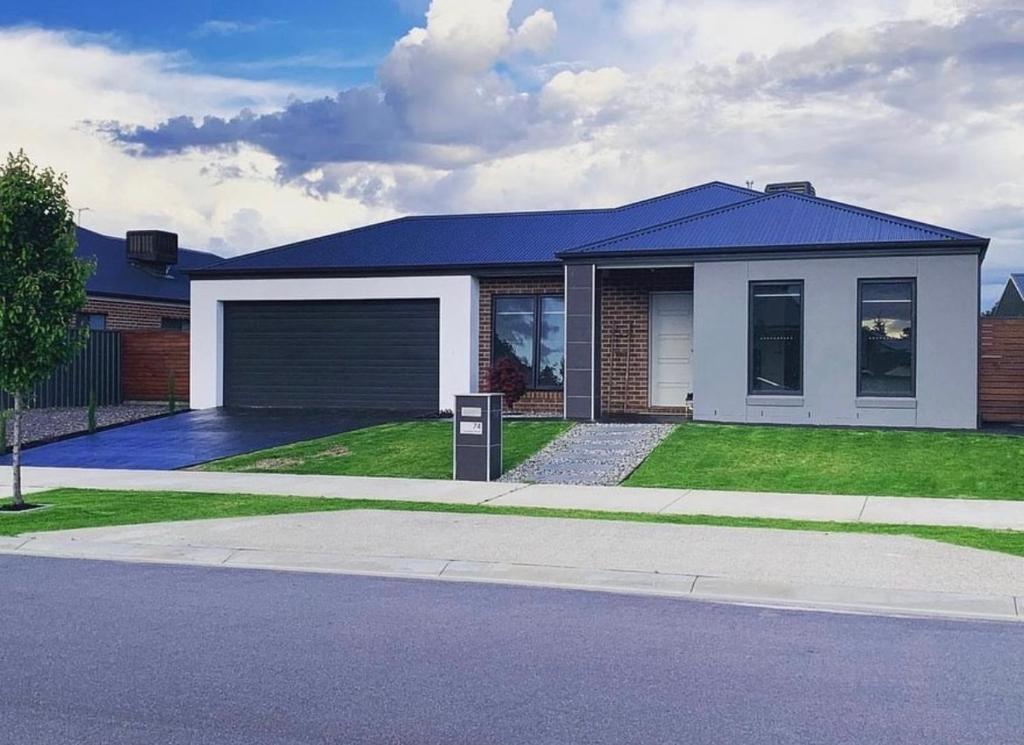 a house with a blue roof and a garage at Wodonga House Huon hill in Bandiana