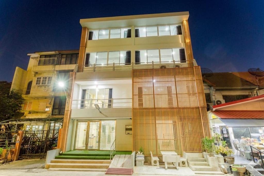 a tall building with tables and chairs in front of it at Rama Residency Sukhumvit Bangkok in Amphoe Phra Khanong