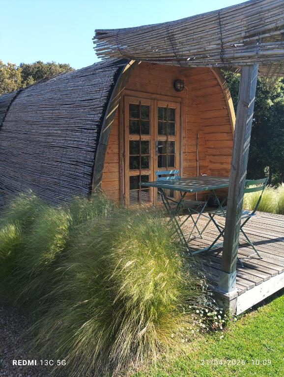 a small wooden cabin with a table in front of it at Su Niberalzu glamping in Fermata di Enas