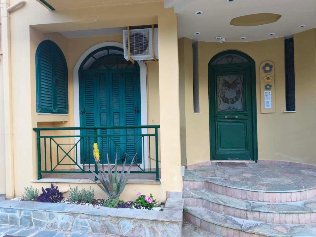 a house with a green door and a balcony at P studios in Sami