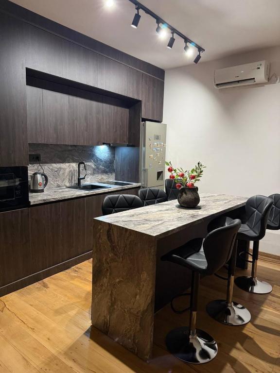 a kitchen with a large island in a kitchen with chairs at Balcony in Shatin