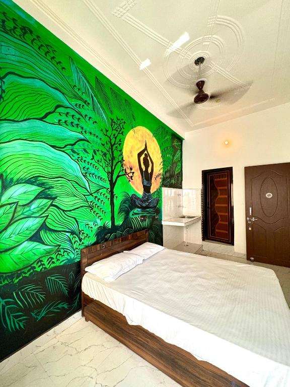 a bedroom with a bed with a painting on the wall at Mountain View Terrace Room Upper Tapovan in Rishīkesh