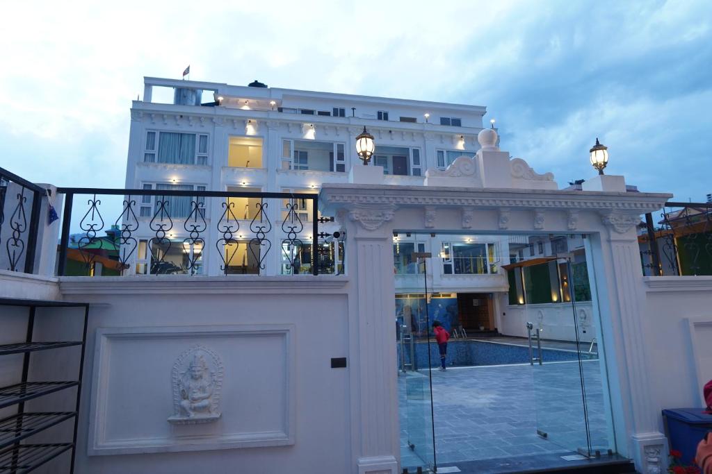 a large white building with a balcony with lights at Lotus Shines & Amenities in Manamaiju