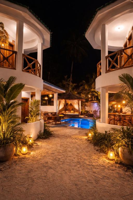 a resort with a swimming pool at night at Jumbo Resort in Paje