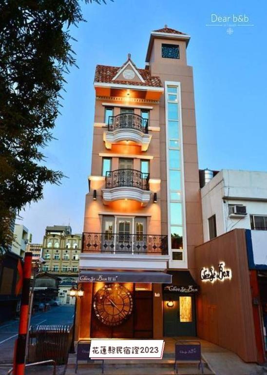 a tall building with two balconies on top of it at Central Cheese Bon Guest House花蓮市中心-起司旅電梯民宿 in Hualien City