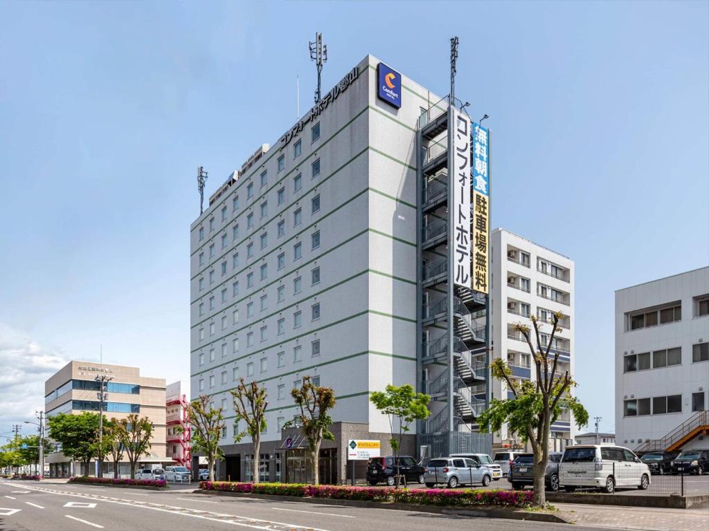 a white building with a sign on the side of it at Comfort Hotel Koriyama in Koriyama