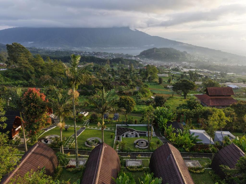 a view of a city with a mountain in the background at Lumbung Hill Glamping in Tabanan