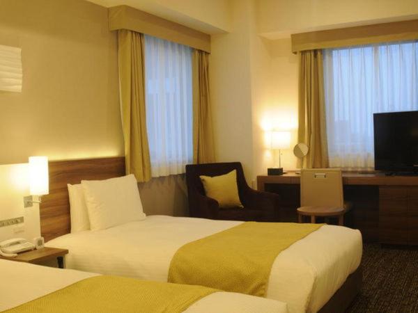 Tempat tidur dalam kamar di Hotel Sunroute Kumagaya Station