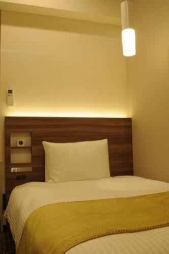 Postel nebo postele na pokoji v ubytování Hotel Sunroute Kumagaya Station