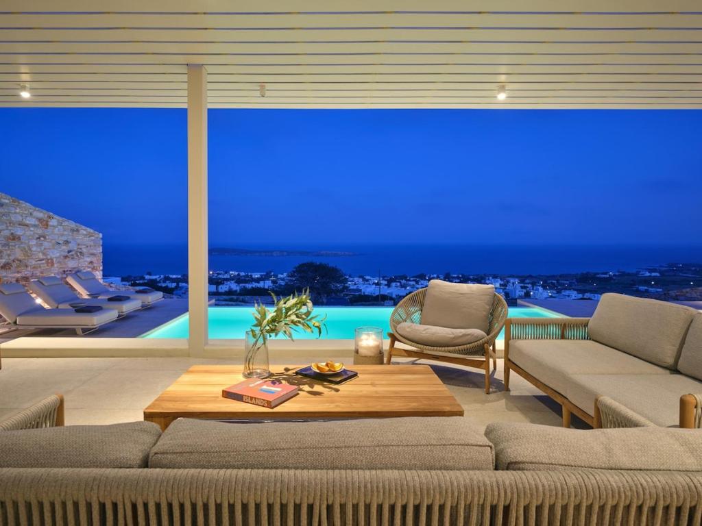 a living room with a view of the ocean at night at Eos Villa in Drios