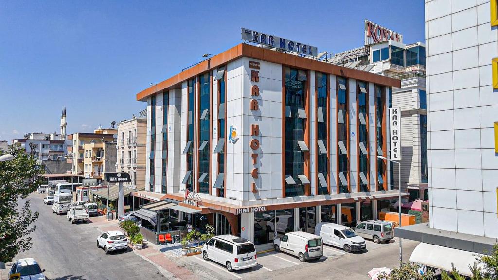 a building on a city street with parked cars at Kar Hotel in Mersin