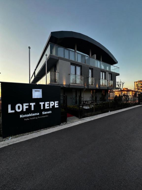 a building with a sign in front of it at Loft Tepe Hotel in Dikmen