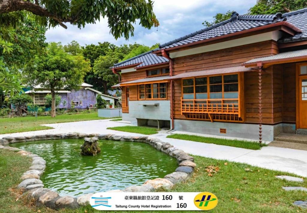 a house with a pond in front of it at Machiya Posong in Taitung City