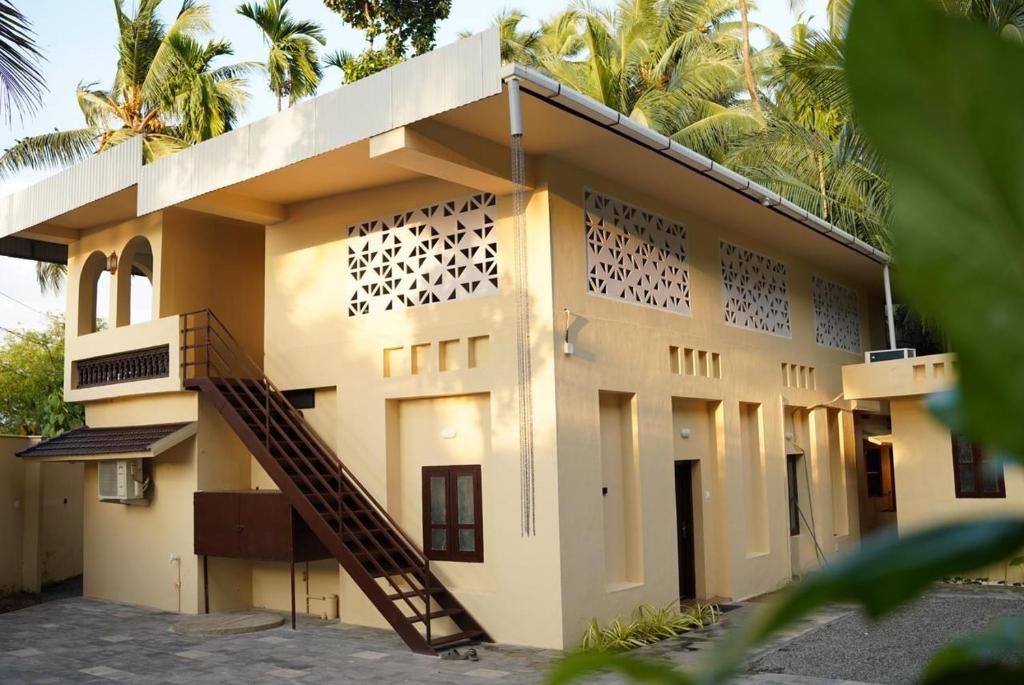 a building with a staircase in front of it at Oakeland By Grovien in Ponnāni