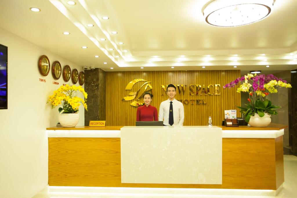 a man and woman standing at a counter in a salon at New Space Hotel Airport in Ho Chi Minh City