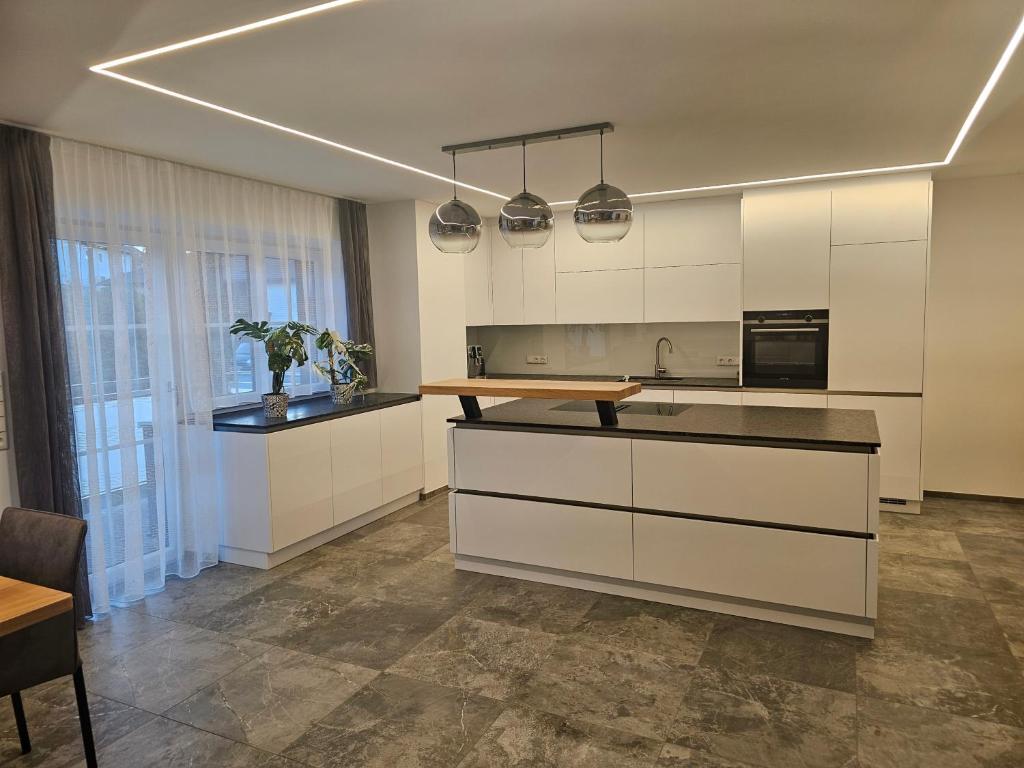 a kitchen with white cabinets and a counter top at Ferienwohnung Scheuringer in Enzenkirchen