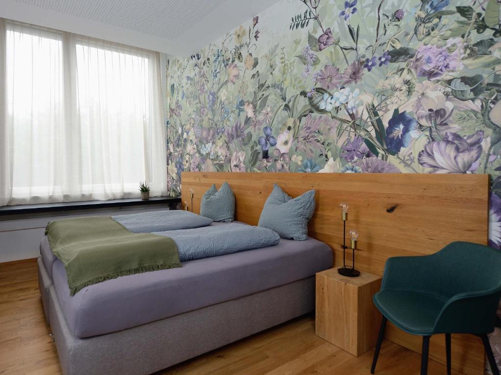 a bedroom with a bed with a floral wallpaper at Hotel Profis in Diepoldsau