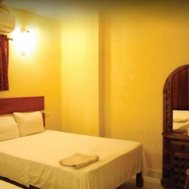 ein Schlafzimmer mit einem Bett, auf dem zwei Handtücher liegen in der Unterkunft Hotel Alberto in Cárdenas