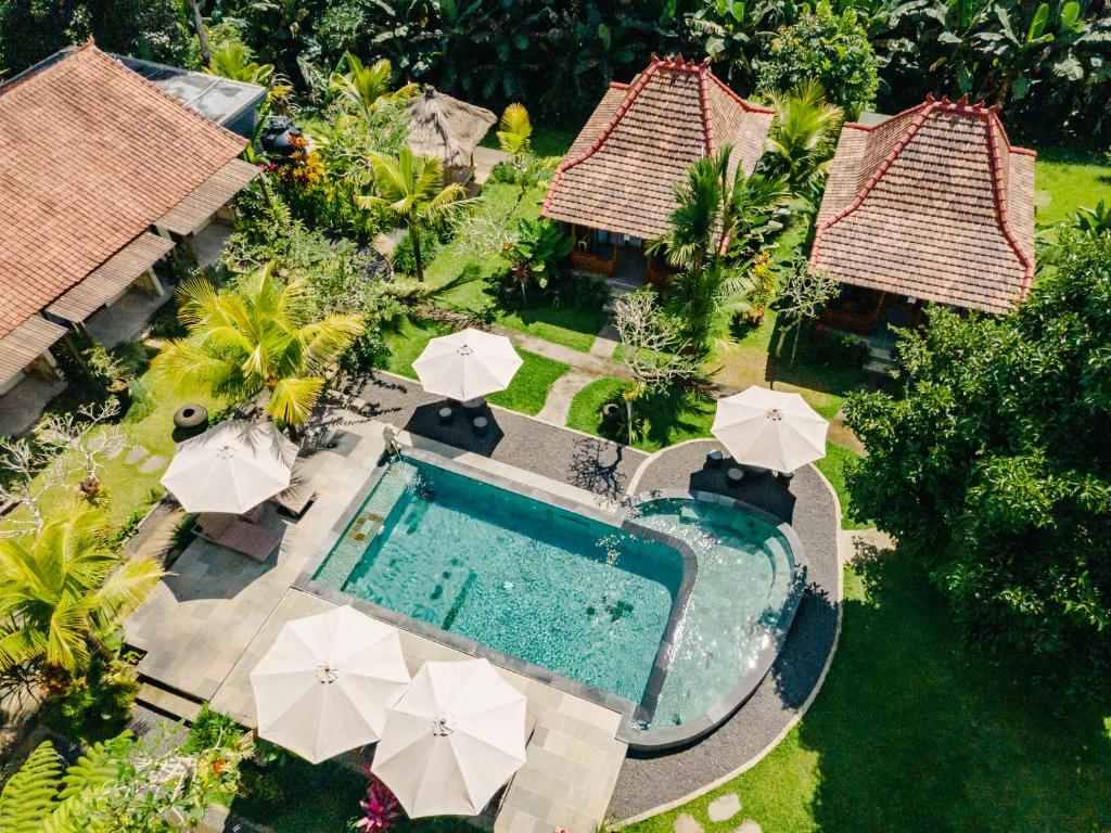 an aerial view of a swimming pool with umbrellas at Puri Kurnia Ayu in Ubud
