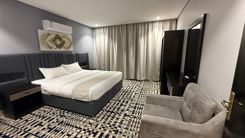 a hotel room with a bed and a chair at Qimam Park Abha 4 in Abha