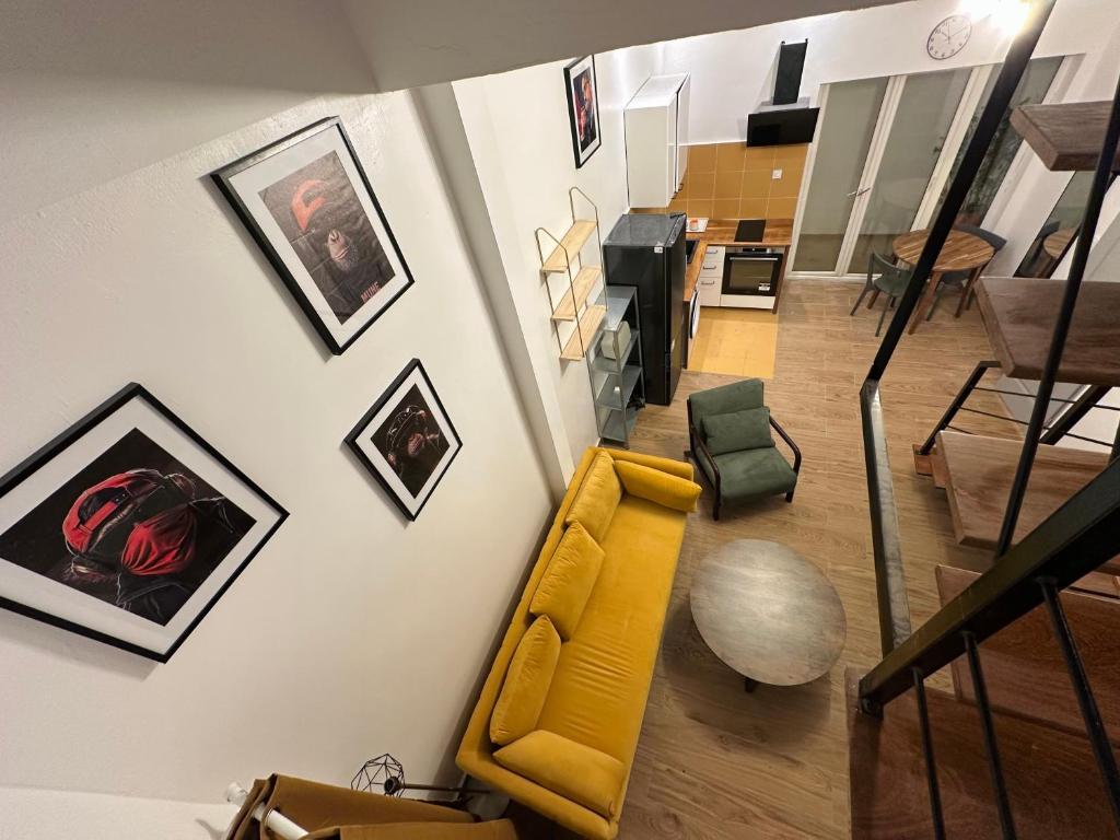 a living room with a yellow couch and pictures on the wall at Urban Loft Dakar by Immo Kit BNB in Dakar