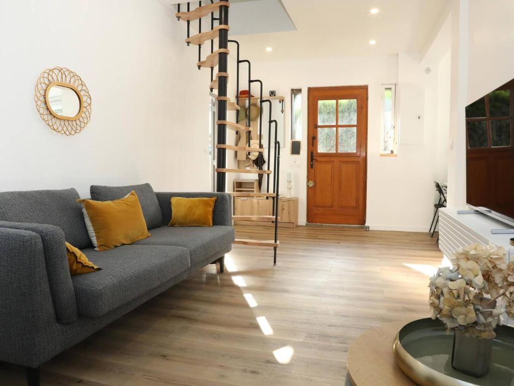 a living room with a couch and a wooden floor at Suite des Princes with Private Garden by La Boîte En Plus in Chantilly