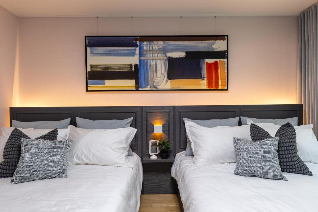 two beds sitting next to each other in a bedroom at 스테이 한집 in Suwon