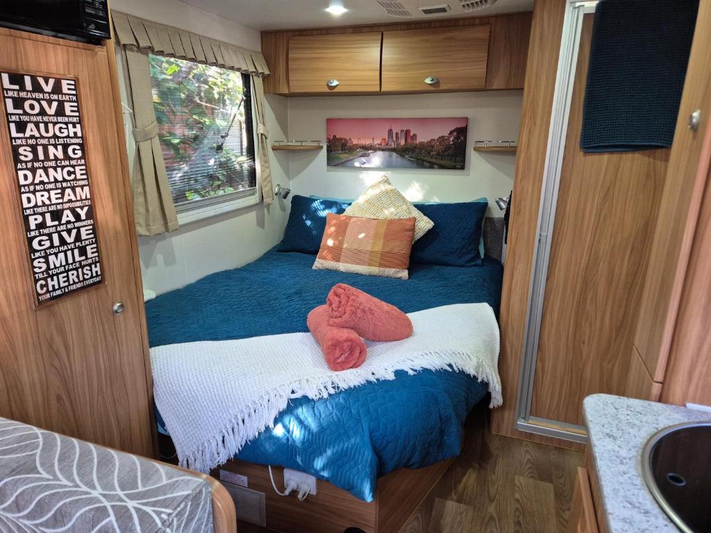 a small bedroom with a bed in an rv at A Tiny Home Experience in a great spot in Melbourne