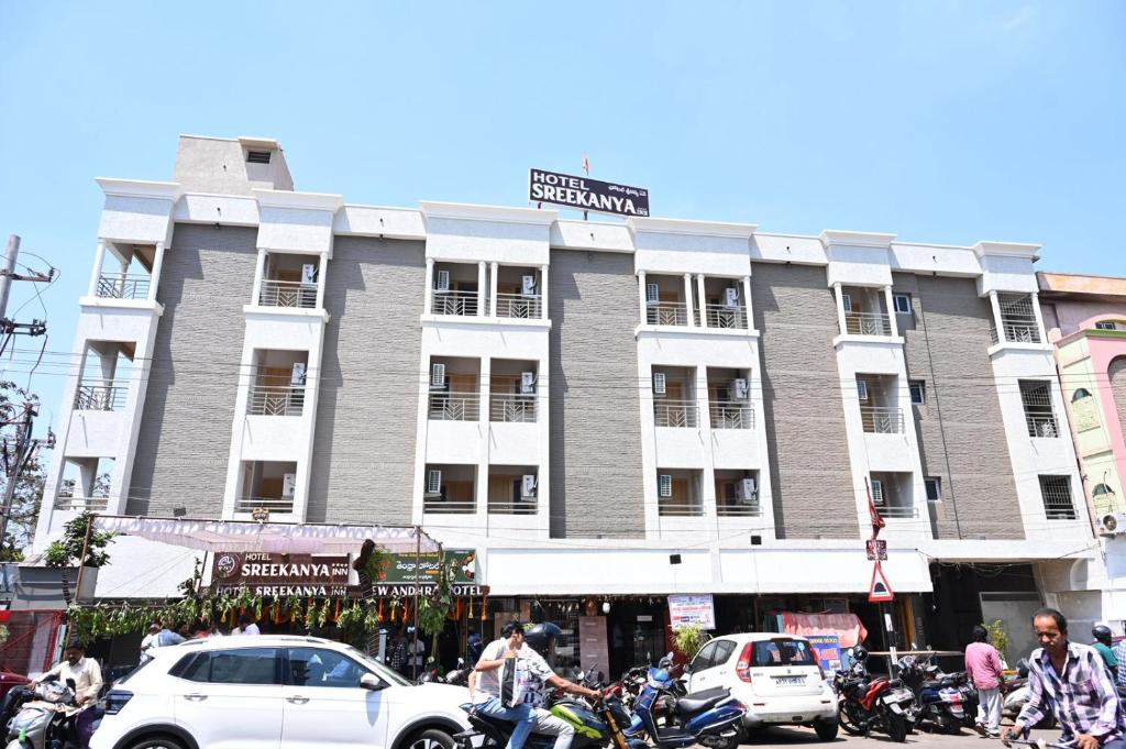a large building on a street with cars and motorcycles at Hotel Sree Kanya Inn in Visakhapatnam