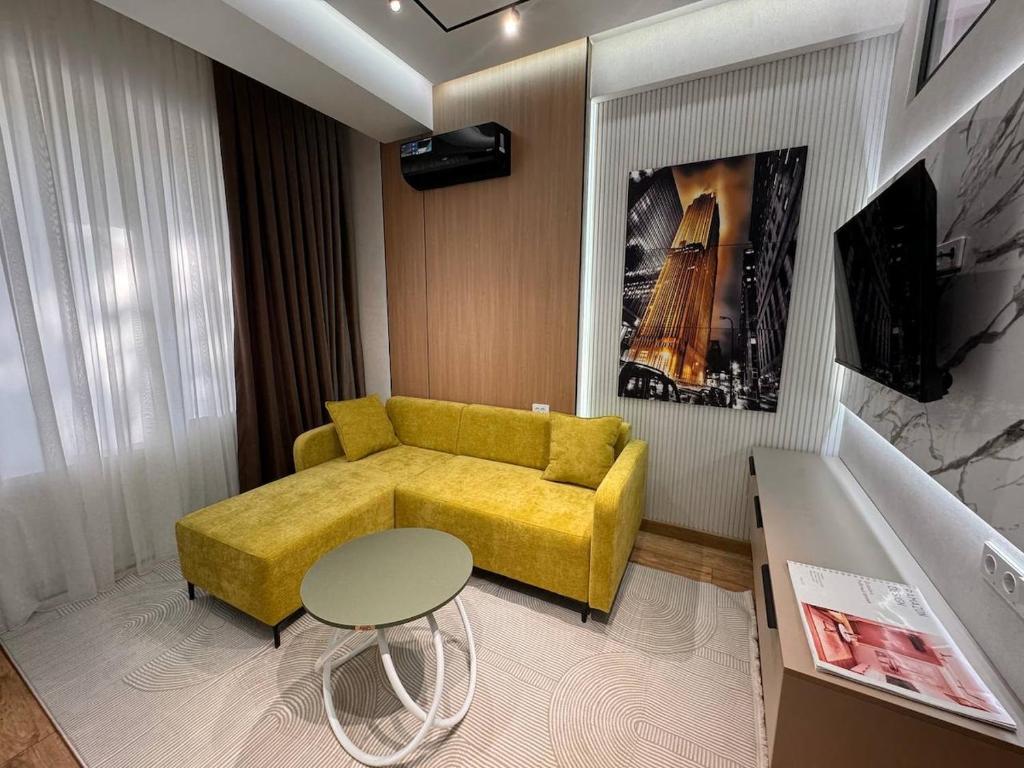 a living room with a yellow couch and a table at Apartment prime residence in Ak-Tyube