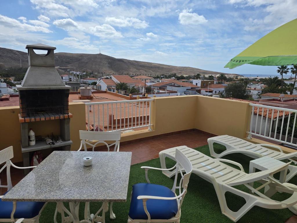 a balcony with a table and chairs and a grill at Tropical Paradise in Tarajalejo