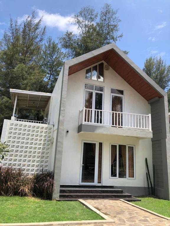 a white house with a balcony at The Kaluna Resort in Lamno