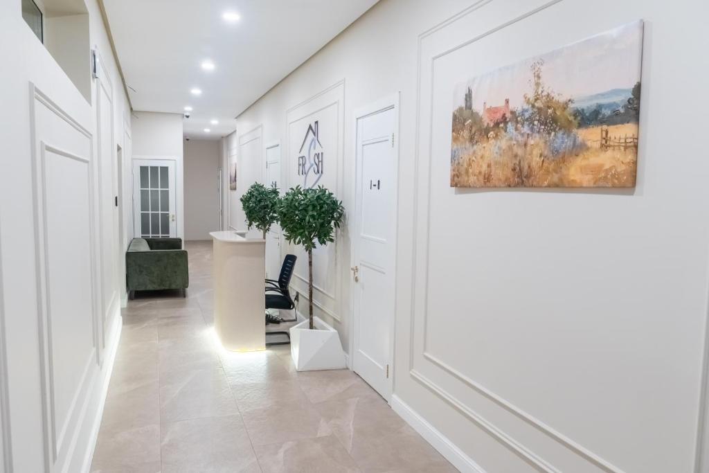 a hallway with white walls and a painting on the wall at Fresh hostel in Almaty