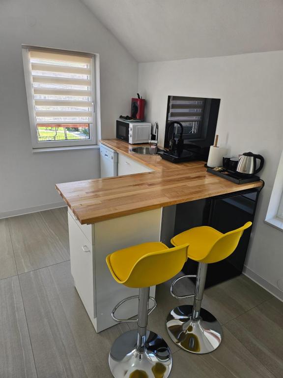 a kitchen with two yellow bar stools at a counter at Studio M in Năsăud