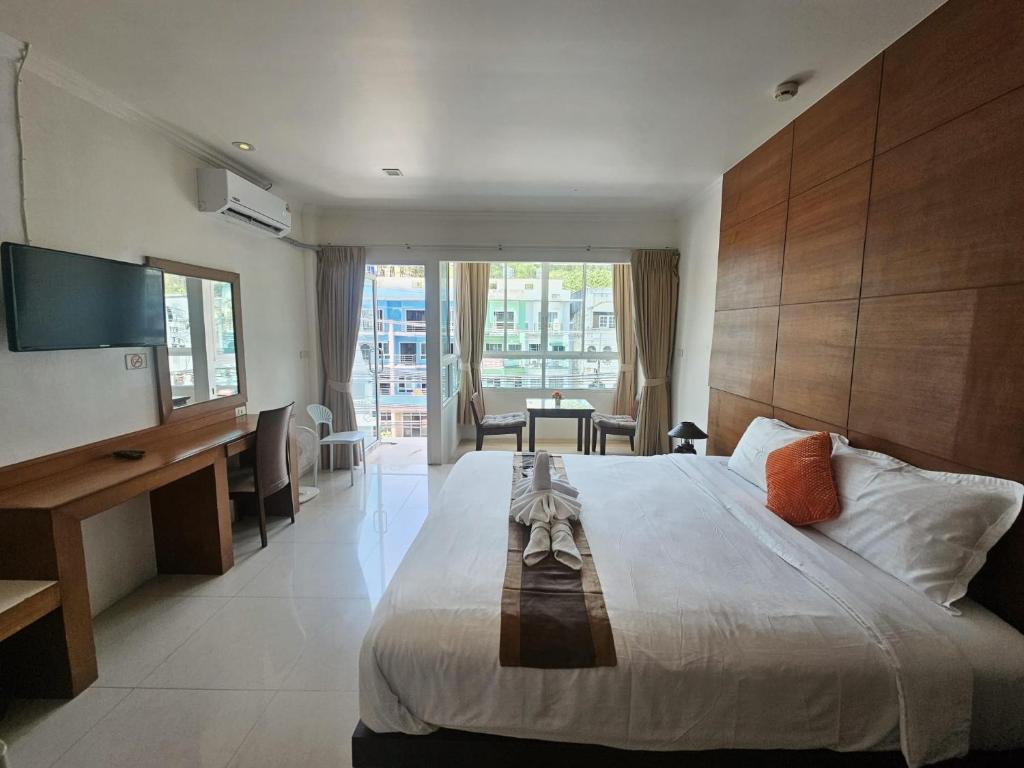 a hotel room with a large bed and a television at SR Phuket in Patong Beach