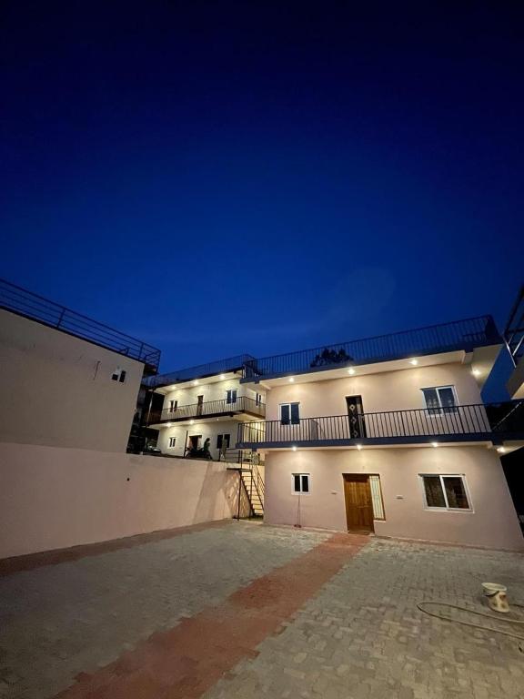 a large white building with a courtyard at night at The Storyhouse in Kūkkāl