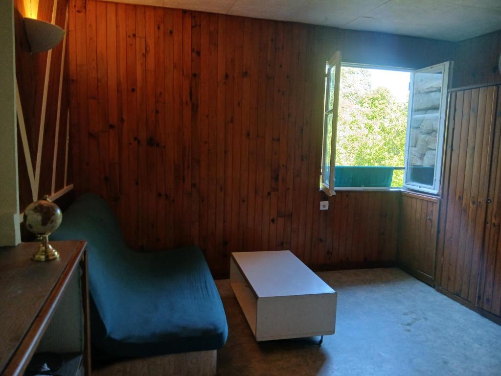 a room with a chair and a table and a window at Studio privatif in Figeac