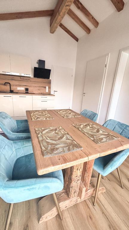 a wooden table with two blue chairs around it at Haus Friedau in Ellmau
