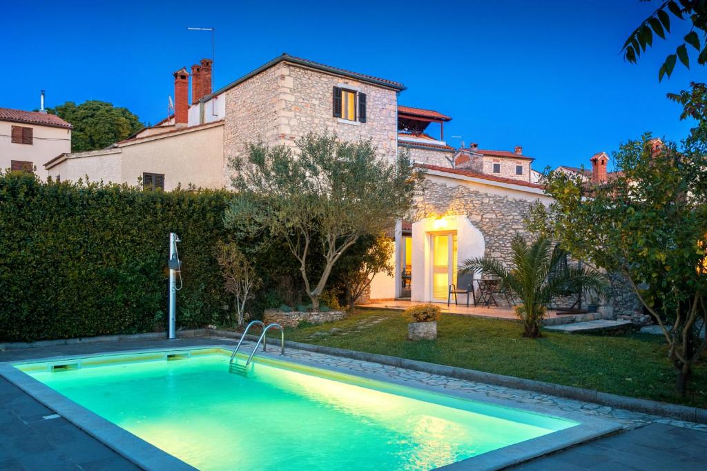 a swimming pool in the backyard of a house at Stonehouse Ewa&Pool in Medulin