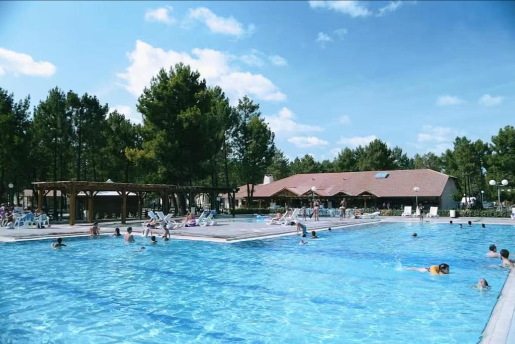 a group of people swimming in a swimming pool at chalet with swimming pool in leisure park in Gujan-Mestras