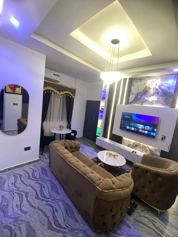 a living room with a couch and a flat screen tv at Asika Luxe Living in Ayobo